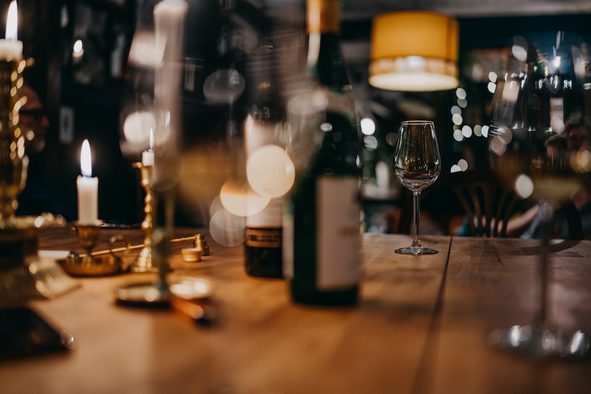 Candlelit wine bar with an open bottle and a tasting glass